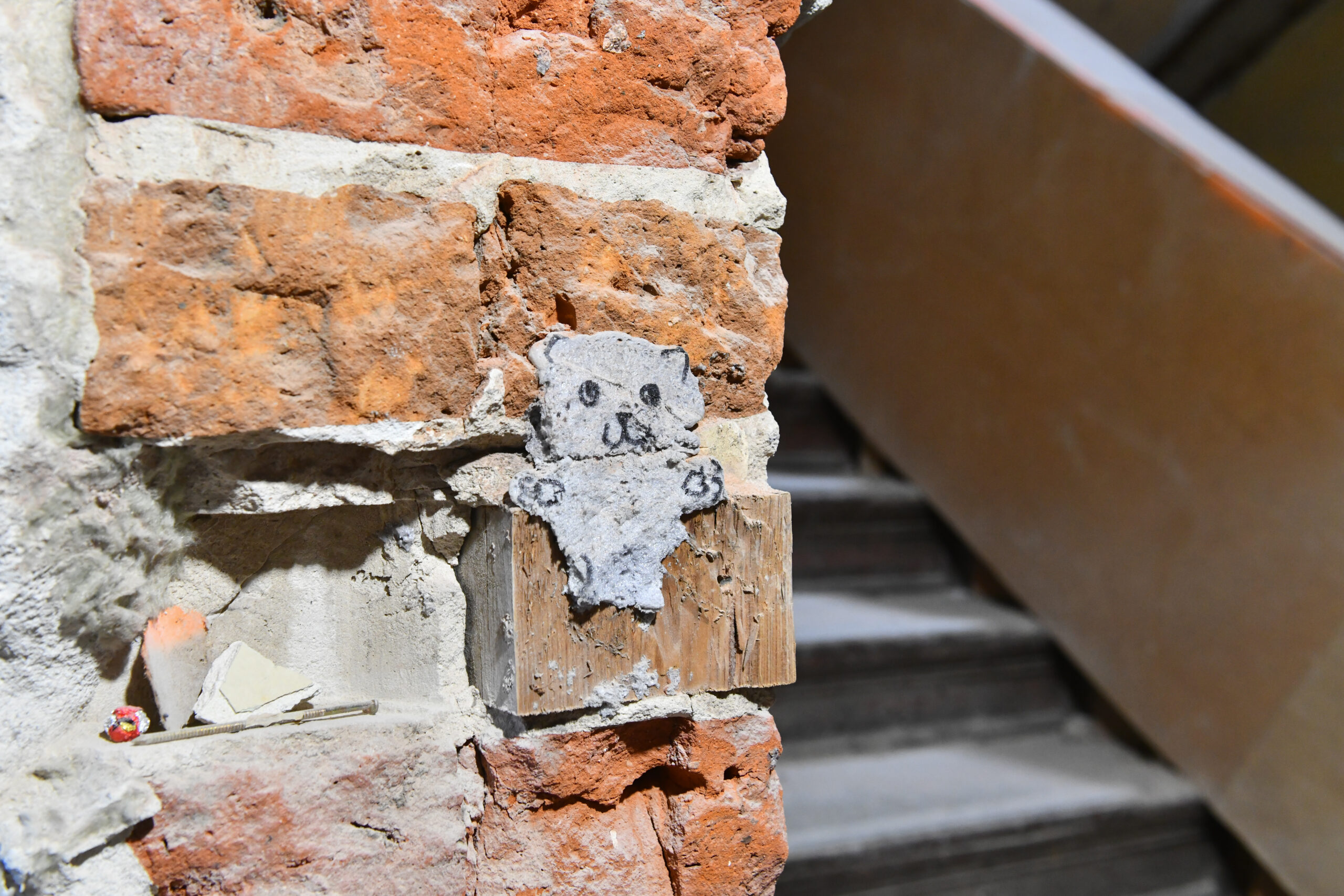 Nahaufnahme einer Bären-Zeichnung auf den alten Backsteinen der Fassade